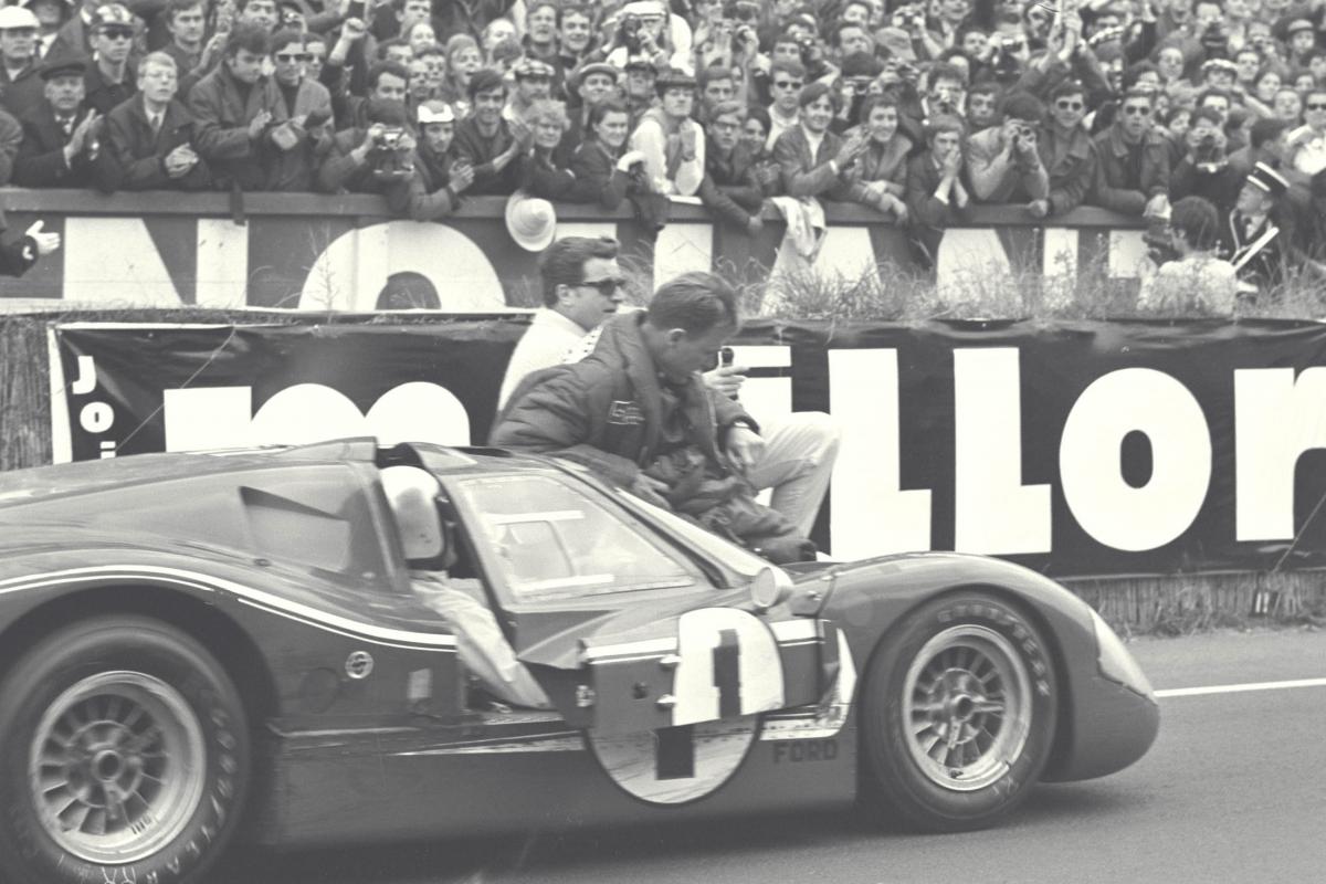 Foyt pilota hacia la línea de meta mientras Gurney está sentado en el capó - Le Mans, Francia, 1967
